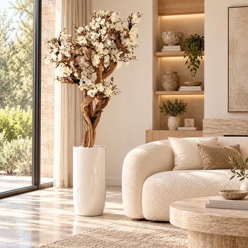 10ft White Magnolia Tree in Glossy Beige St. Tropez Planter — styled in a living room beside a sofa